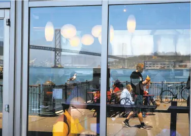  ?? Michael Macor / The Chronicle 2016 ?? Patrons enjoy lunch at the Hog Island Oyster Co. along the promenade of the Ferry Building on San Francisco’s Embarcader­o. Whether city voters can set limits on waterfront developmen­t is at issue.