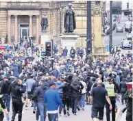  ??  ?? TENSION
Crowds gather near a statue in George Square