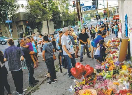  ?? Photograph­s by Marcus Yam Los Angeles Times ?? COMMUNITY members mourn for Melyda Corado, the Trader Joe’s store manager who was killed Saturday in Silver Lake.