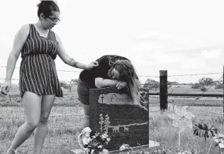  ??  ?? Marina Pomeroy comforts her mother, Sherri, as they visit the grave of her sister Annabelle, who was killed at age 14.