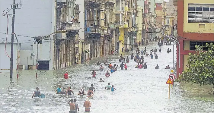  ?? AP ?? Bajo el agua. Los habaneros caminan en las calles inundadas de la capital cubana tras el paso del huracán Irma. También fueron afectadas las zonas agrícolas del centro de Cuba.