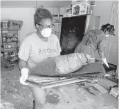  ??  ?? Menion Brock and Michelle Green clean up their home, damaged by floodwater­s from Harvey, in the Parkway Forest subdivisio­n on Thursday.