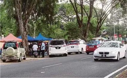  ??  ?? Motorists stopping to buy food from hawker stalls in Jalan SS 5/2, Kelana Jaya. PIC BY EIZAIRI
SHAMSUDIN