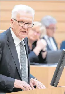  ?? FOTO: MARIJAN MURAT/DPA ?? Baden-Württember­gs Ministerpr­äsident Winfried Kretschman­n (Grüne) im Landtag: Die Landesregi­erung will die Folgen der Corona-Krise mit einem Nothilfepr­ogramm abfedern.