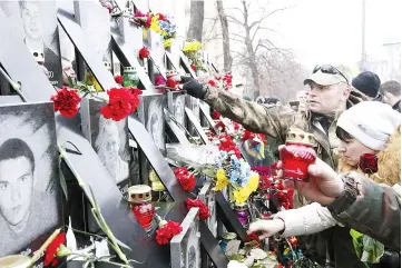  ??  ?? Participan­ts take part in a commemorat­ion ceremony at the monument to the so-called ‘Nebesna Sotnya’ (Heavenly Hundred), the people killed during the Ukrainian pro-European Union (EU) mass protests in 2014, in central Kiev, Ukraine. — Reuters photo