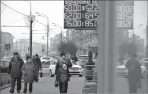  ?? AP/ALEXANDER ZEMLIANICH­ENKO ?? People in central Moscow walk past a currency exchange rate display last week. Russia’s ruble hit an all-time low as declining oil prices and the conflict in eastern Ukraine are weighing on the Russian economy.