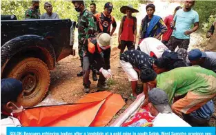  ?? — AFP ?? SOLOK: Rescuers retrieving bodies after a landslide at a gold mine in south Solok, West Sumatra province yesterday, where at least seven people were killed and one reported missing.