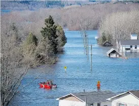  ?? ANDREW VAUGHAN / THE CANADIAN PRESS ?? A Coast Guard vessel heads across a flooded area at Darlings Island, N.B., last week. Ottawa is stepping into help residents clean up in the flood-ravaged province.