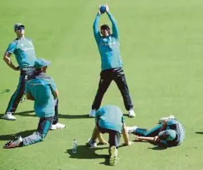  ?? EPA PIC ?? Australia’s David Warner (centre) stretches with his fellow players during a training session yesterday.