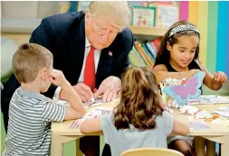  ?? — AP ?? President Donald Trump writes in a coloring book during a visit with a group of children at the Nationwide Childrens Hospital, Friday in Columbus, Ohio.