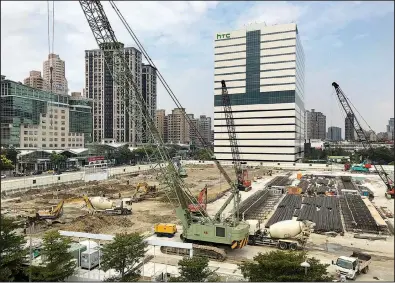  ?? AP/JOHNSON LAI ?? Constructi­on crews work near the HTC headquarte­rs building in New Taipei City, Taiwan, on Thursday.