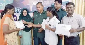 ?? PIC BY AZAHAR HASHIM ?? R. Prevena (front row, second from right) with her award at SMK Sultan Badlishah in Kulim yesterday. With her are her parents.