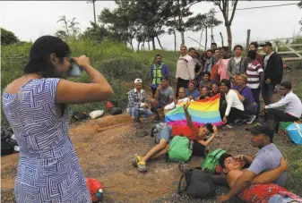  ?? Rodrigo Abd / Associated Press ?? A group of lesbian, gay, bisexual, transgende­r and queer migrants traveling with the caravan hoping to reach the U.S. border take a photo around a gay pride flag in Sayula, Mexico, Nov. 3.