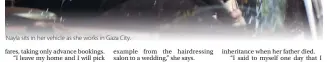  ??  ?? Nayla sits in her vehicle as she works in Gaza City.