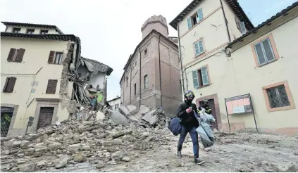  ?? Alessandra Tarantino / AP Photo ?? The bell tower of the Santa Maria in Via church in Camerino, central Italy, collapsed after an earthquake measuring 5.5 on the Richter scale destroyed part of the town. Many residents fled their homes, taking their belongings with them.