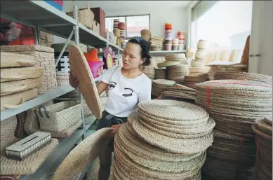  ?? PROVIDED TO CHINA DAILY ?? A woman in Binzhou, Shandong province, sorts straw and willow products, which are made in a company she owns and sold online.