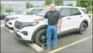  ?? Westside Eagle Observer/SUSAN HOLLAND ?? Gravette police chief Chuck Skaggs poses with the two new police cruisers recently purchased for the city of Gravette. Skaggs told council members at the May 12 committee of the whole meeting that the vehicles would soon be outfitted and ready for the road. He thanked them for approving the purchase.