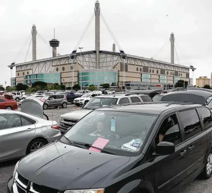  ?? Bob Owen / Staff file photo ?? Thousands of cars line up in the parking lot of the Alamodome in April, when the San Antonio Food Bank used it to hold an emergency food distributi­on.