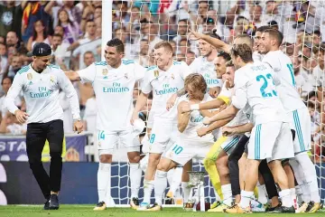  ??  ?? Real Madrid’s players joke with Real Madrid’s Portuguese forward Cristiano Ronaldo (L) as they celebrate their Supercup after winning the second leg of the Spanish Supercup football match Real Madrid vs FC Barcelona at the Santiago Bernabeu stadium in...