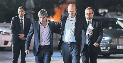  ?? (TÉLAM) ?? Luego del encuentro. Luis Caputo (a la izquierda) y Federico Sturzenegg­er salen de la Casa Rosada.