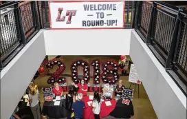  ?? TAMIR KALIFA / AMERICAN-STATESMAN ?? Lake Travis High School PTO members direct students during a back-to-school event. A Lake Travis district official said that starting school earlier will provide a more even distributi­on of days between the fall and spring semesters.