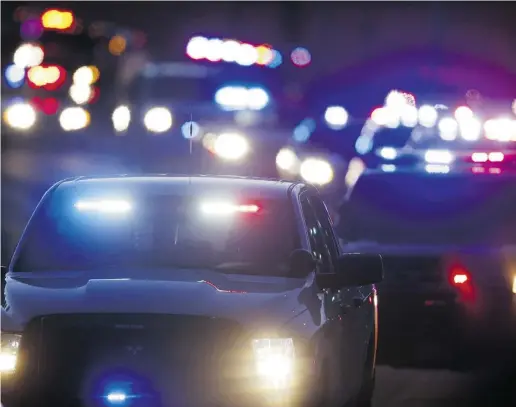  ?? David Zalubowski / The Associated Press ?? Police follow a hearse carrying slain police officer Garrett Swase — one of three killed in a mass shooting at a nearby Planned Parenthood clinic — to the Evergreen Cemetery in Colorado Springs, Colo., on Dec. 4.