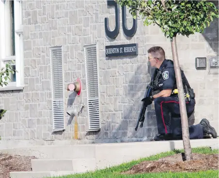  ?? THE CANADIAN PRESS ?? A police officer takes up a position in response to shootings in St. Catharines, Ont., on Thursday.