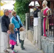  ??  ?? Mike and Karen Jervis of Peachland and their grandchild­ren Charley and Jaxon Jervis from Whistler check out the scarecrows outside the Gasthaus restaurant.