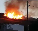  ??  ?? Flames from the fire at Dunbur come close to houses on Seafield Estate.