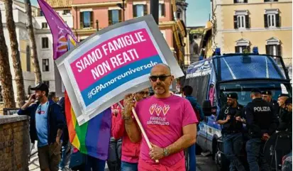  ?? ANDREAS SOLARO/AFP VIA GETTY IMAGES ?? Supporters of surrogacy held signs saying “We are families, not crimes” in Rome on Friday.