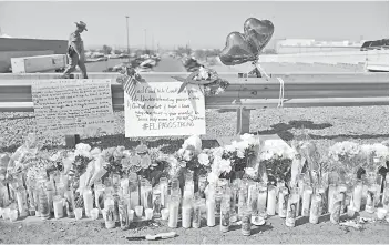  ?? — AFP photo ?? A police officer walks past a makeshift memorial outside Walmart, near the scene of a mass shooting in El Paso, Texas.