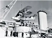  ??  ?? Corkhill, top, and a Walrus being manoeuvred on board a light cruiser