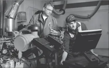  ?? JIMMY JEONG POSTMEDIA NEWS ?? Instructor Rob Fedechko watches from behind as Northern Alberta Institute of Technology student Bradley MacIntosh, who is enrolled in the Edmonton college’s heavy equipment program, checks a blueprint on a computer.