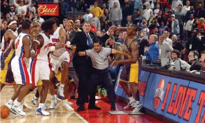  ?? Photograph: Getty Images/Getty Images Sport ?? Indiana’s Ron Artest, head coach Rick Carlisle, referee Tommy Nunez and several Detroit Pistons players during the infamous ‘Malice at the Palace’ brawl in 2004.