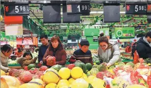  ?? SI WEI / FOR CHINA DAILY ?? Consumers choose fruits at a supermarke­t in Lianyungan­g, Jiangsu province.