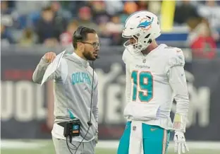  ?? STEVEN SENNE/AP ?? Dolphins quarterbac­k Skylar Thompson (right) talks with coach Mike McDaniel during the second half of Sunday’s game in Foxborough, Mass.