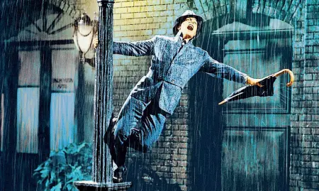  ??  ?? Seminale Gene Kelly in «Cantando sotto la pioggia» (1952) di Stanley Donen: l’attore e il regista cambiarono la storia del musical