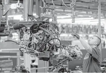  ?? LM Otero / Associated Press file ?? An auto worker assembles an SUV at the General Motors plant in Arlington. Rebecca Lindland of Kelley Blue Book says meeting the current standards will be “extremely challengin­g” because electric vehicle sales have been slow and customers are buying...