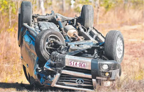  ??  ?? MESS: A damaged car lays on its roof after a crash on the Bruce Highway, which left a woman injured.