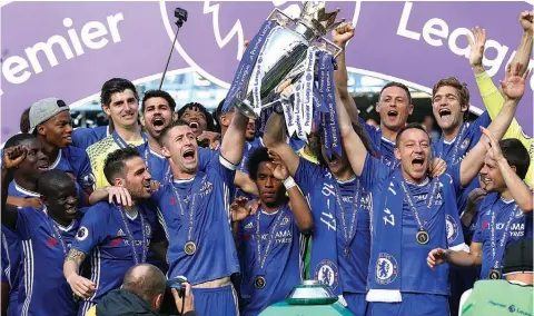  ?? PHOTO: AFP. ?? Outgoing captain, John Terry (right) and Gary Cahill (centre left) hold up the English Premier League trophy as Chelsea celebrate their league title at the Stamford Bridge, London…yesterday.