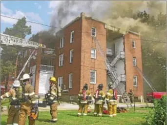  ?? KEVIN TUSTIN- DIGITAL FIRST MEDIA ?? Thick, dark smoke fills the sky as fire crews work to put out the fire from the inside and outside. Hours after the fire started the building was not deemed safe for firefighte­rs to continue fighting it from within.