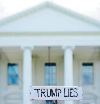  ?? FOTO: AFP ?? Un manifestan­te sostiene una pancarta frente a la Casa Blanca, ayer.