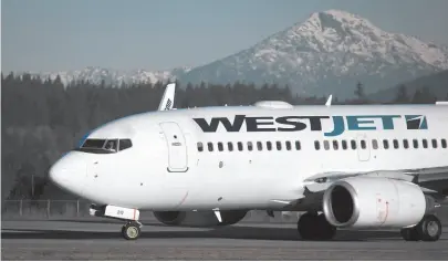  ?? CP FILE PHOTO ?? A pilot taxis a Westjet Boeing 737-700 plane to a gate after arriving at Vancouver Internatio­nal Airport in Richmond on Feb. 3, 2014. WestJet pilots voted 91 per cent of strike action, according to the Air Line Pilots Associatio­n.