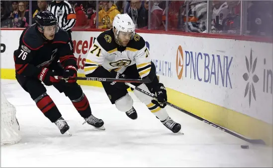  ?? KARL B DEBLAKER — THE ASSOCIATED PRESS ?? Boston Bruins forward Taylor Hall (71) protects the puck from Carolina Hurricanes defenseman Brady Skjei during the first period of a Jan. 29 game in Raleigh, N.C.