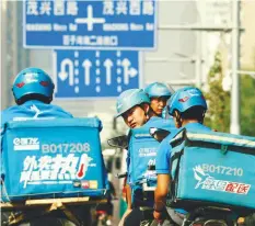  ??  ?? Riders of the food delivery service Ele.me prepare to start their morning shift after an internal security check in Beijing, China.