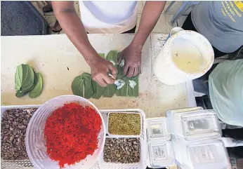  ??  ?? TUCK IN: A Myanmar migrant worker makes traditiona­l snacks at an eatery in Phuket that caters to the migrant community. Some migrants who have enough savings open their own businesses.