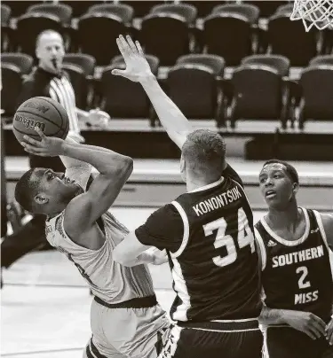  ?? Karen Warren / Staff photograph­er ?? Rice guard Quincy Olivari, left, shoots against Southern Miss’ Artur Konontsuk during the second half. Olivari finished with 29 points, including 6-of-11 from 3-point range, as the Owls ended a five-game skid.