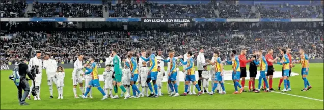  ?? ?? Los jugadores de Real Madrid y Valencia se saludan antes de empezar el partido en un Bernabéu con 51.926 espectador­es en sus gradas.