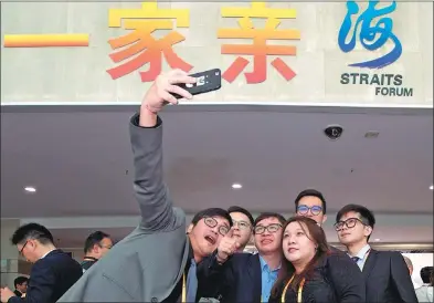  ?? JIANG KEHONG / XINHUA ?? Several participan­ts from Taiwan pose for a photo in front of the venue hosting the ongoing Straits Forum in Xiamen, Fujian province.