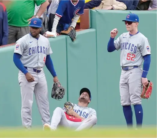  ?? AP ?? Alexander Canario (left) and Pete Crow-Armstrong (right) stand next to Christophe­r Morel after he landed hard while catching a fly in the seventh inning Saturday.